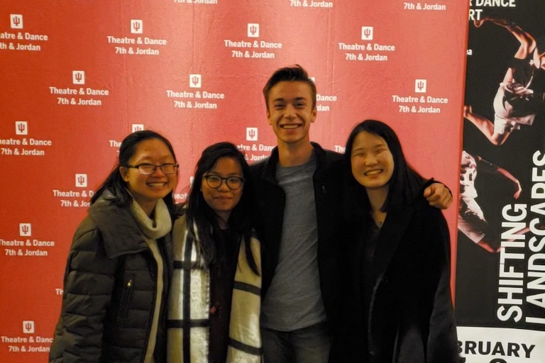 Christina Yang and three friends pose for a photo op in front of a Theatre and Drama department runway backdrop